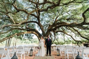 Outdoor wedding ceremony at a Houston Texas wedding venue with oak trees, lake view, greenery and elegant design features