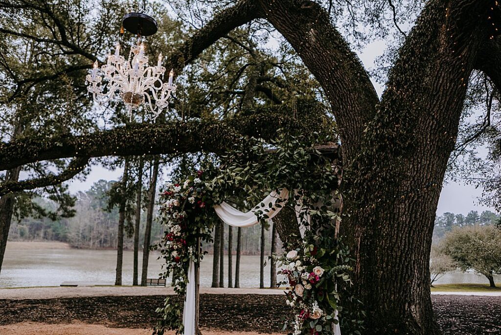 ceremony arbor filled with roses under oak tree