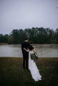 Houston Texas bride and groom pose for wedding day photos at their outdoor wedding ceremony with lake views & luxury landscaping