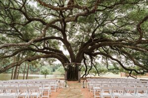 Houston Texas bride and groom pose for wedding day photos at their outdoor wedding ceremony with lake views & luxury landscaping