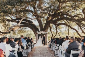 Outdoor wedding ceremony with historic oak tree and lakefront views new Houston Texas