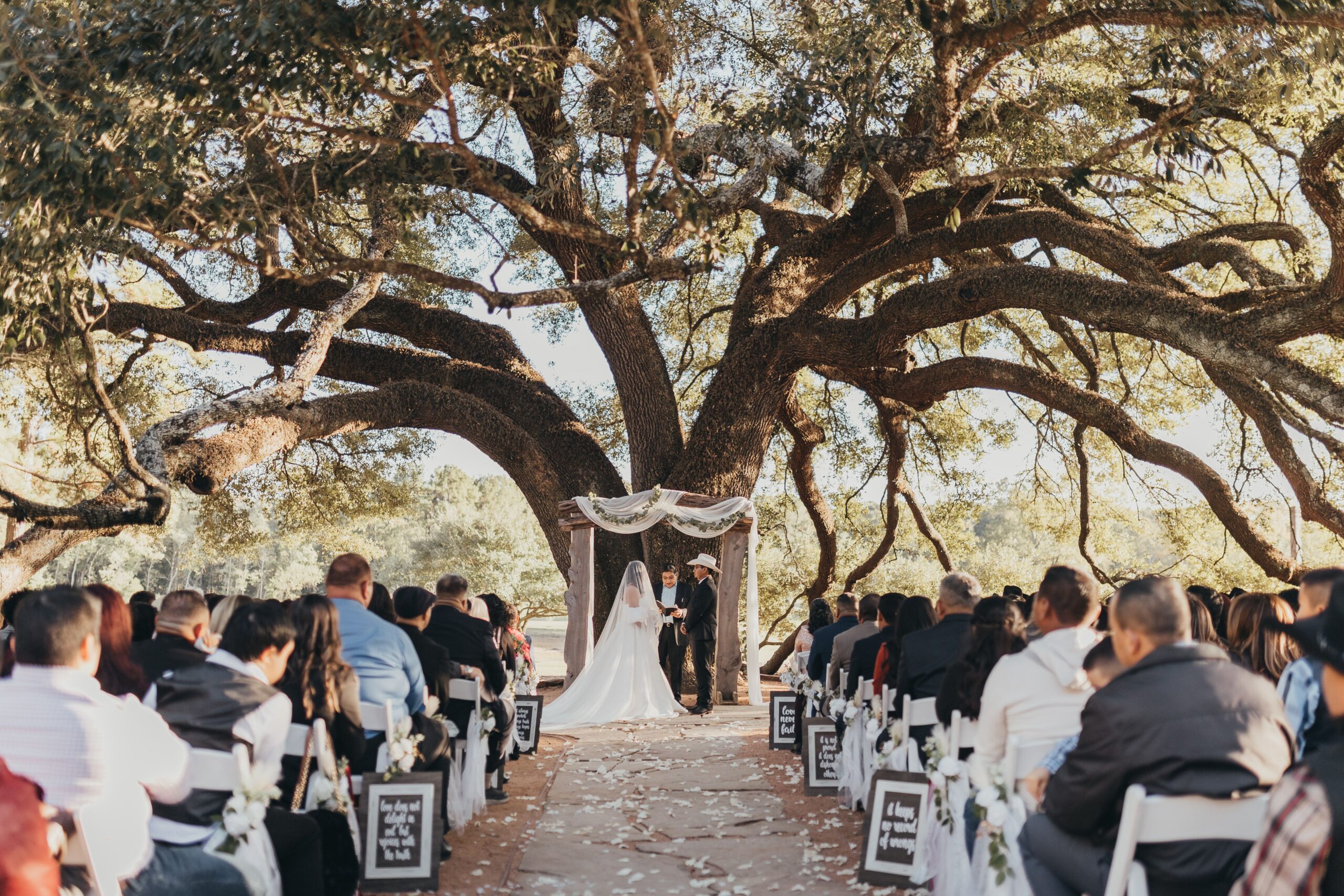 Houston Texas wedding venue bride and groom exchange vows at their elegant outdoor wedding ceremony.