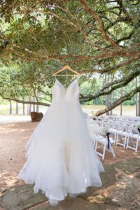 Beautiful outdoor wedding ceremony with elegant chairs, wedding arch, chandelier and lakefront views