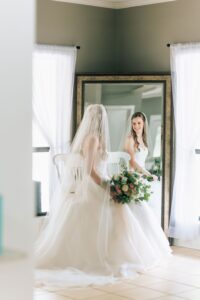 Bride wearing a mantilla veil posing under the historic oak tree at Pine Lake Ranch wedding venue.
