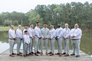 Groomsmen wearing grey wedding suits at a outdoor wedding ceremony near Houston