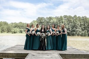 30 Meaningful Christian Wedding Traditions for Houston Couples 6 Bride & bridesmaids pose for photos by the lake at their wedding venue near Houston