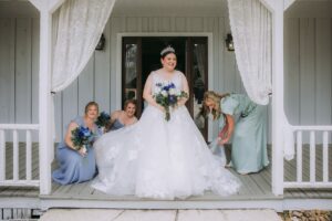 The Ultimate Houston Date Night Bucket List 8 Beautiful blue dresses on bridesmaids as they assist our lovely bride adjusting her wedding dress before the walk down the aisle at our Montgomery Texas wedding venue near Houston