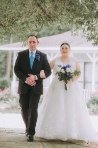 Planning The Perfect Houston Wedding Weekend 12 Bride is walking down the aisle with her father on a wedding Saturday at a garde wedding venue in Montgomery Texas near Houston